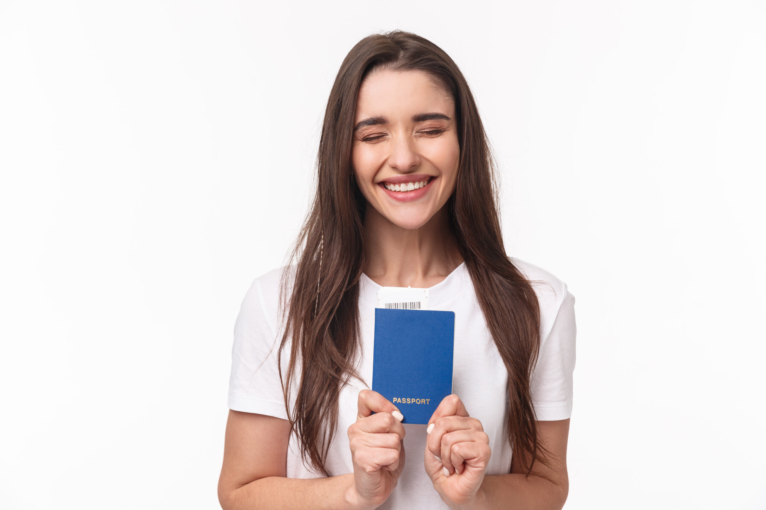Travelling, holidays, summer concept. Portrait of cheerful happy, laughing girl close eyes and smiling enthusiastic, receive her pasport to travel abroad, finally sitting in airport ready for journey.